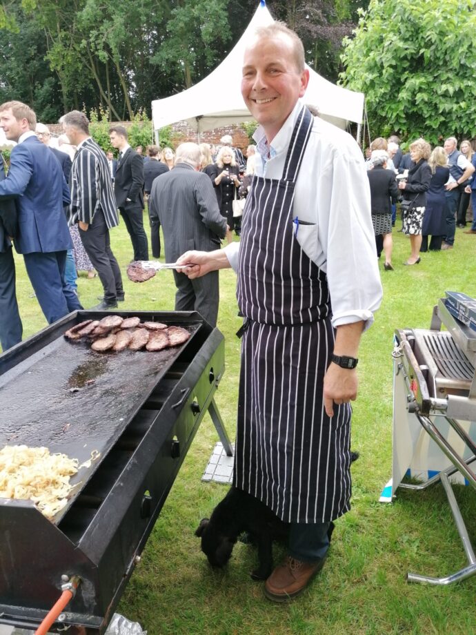 Karl smiling cooking burgers